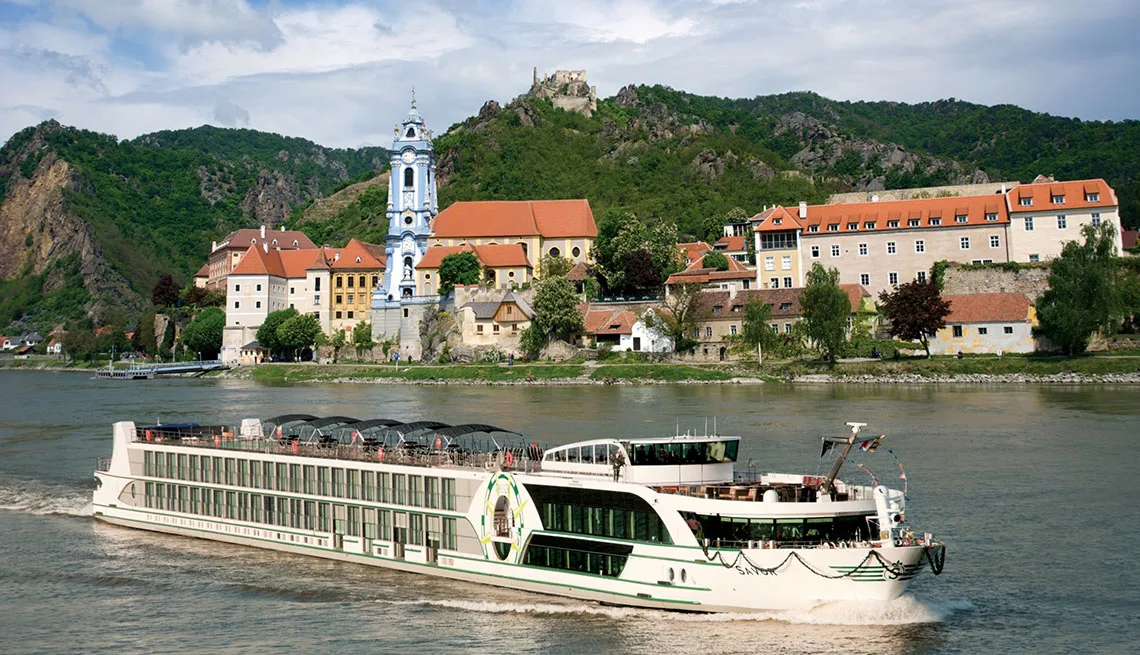 River cruise ship on the Danube below the Dürnstein castle ruins in the Wachau valley
